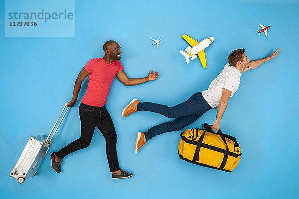 Zwei Männer mit Koffern eilen zu ihrem Flug.