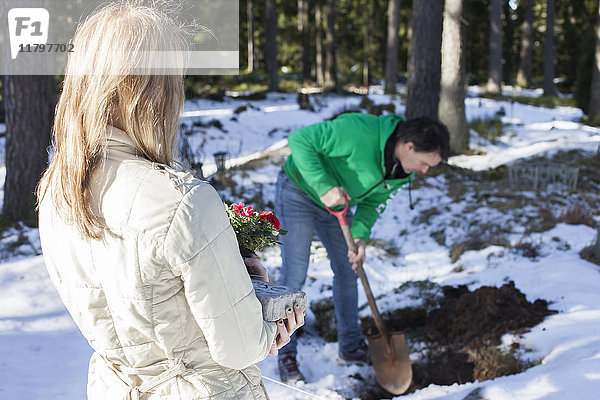 Mädchen und ihr Vater bereiten Grab für Haustier vor