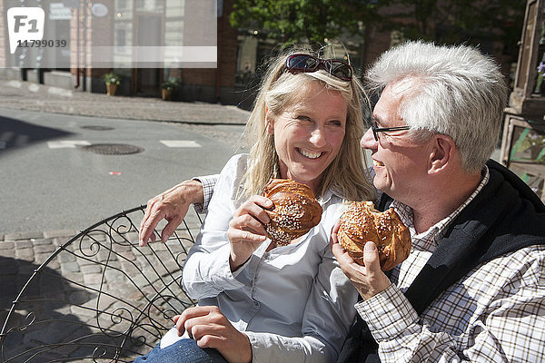 Älteres Paar isst Croissants in einem Straßencafé