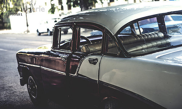 Nahaufnahme eines klassischen Autos aus den 1950er Jahren  das an einer Straße geparkt ist.