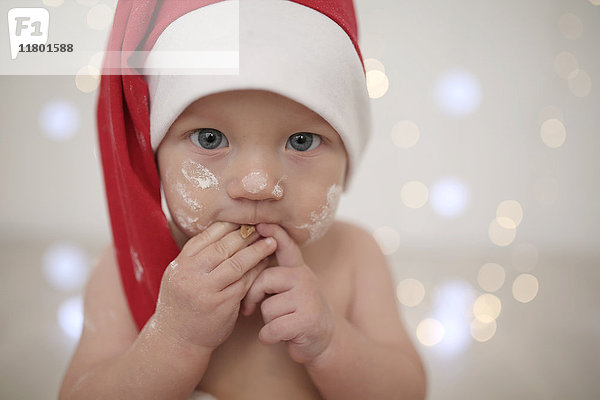Porträt eines Babys mit Weihnachtsmannmütze
