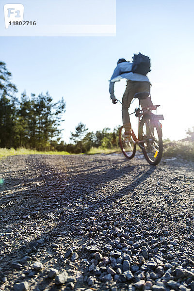 Mann auf Fahrrad in ländlicher Umgebung