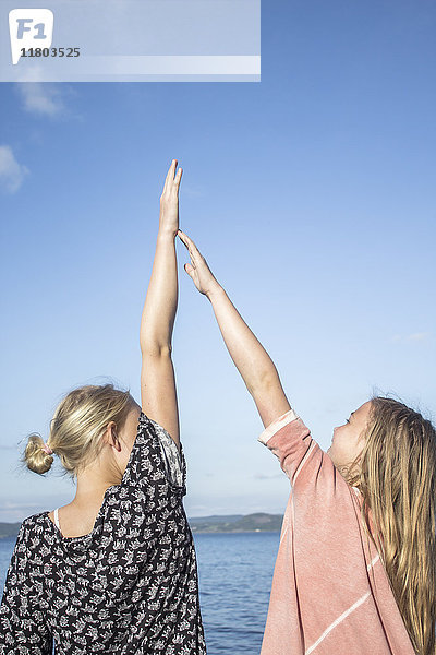 Zwei Mädchen geben sich die Hand  das Meer im Hintergrund