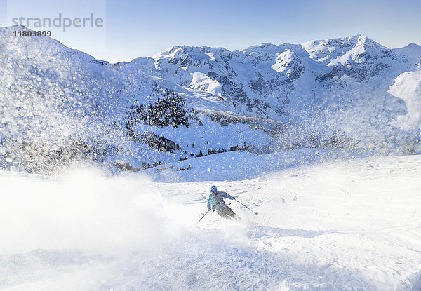 Mann beim Skifahren auf Schnee gegen den Himmel