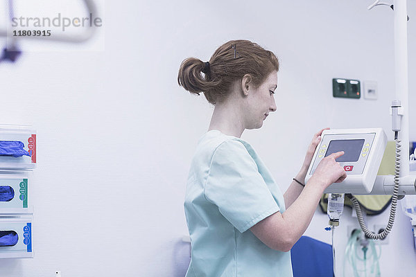 Weibliche Krankenschwester  die medizinische Geräte bedient