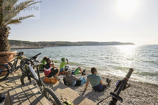 Radfahrer sitzen am Strand und entspannen sich