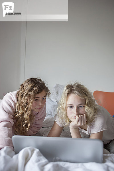Zwei Teenager-Mädchen benutzen Laptop im Schlafzimmer