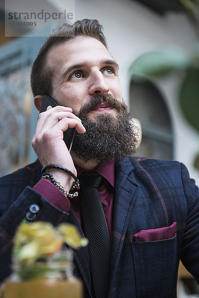 Junger Mann spricht mit einem Mobiltelefon