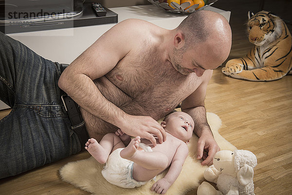 Vater spielt mit seinem kleinen Jungen auf dem Boden