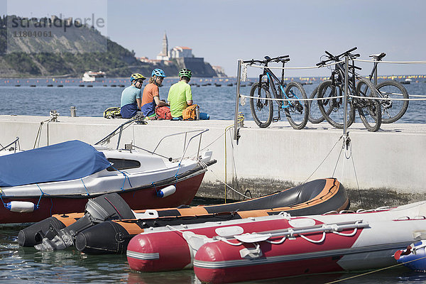 Radfahrer  die sich mit ihren Fahrrädern auf einem aufblasbaren Floß auf dem Steg ausruhen
