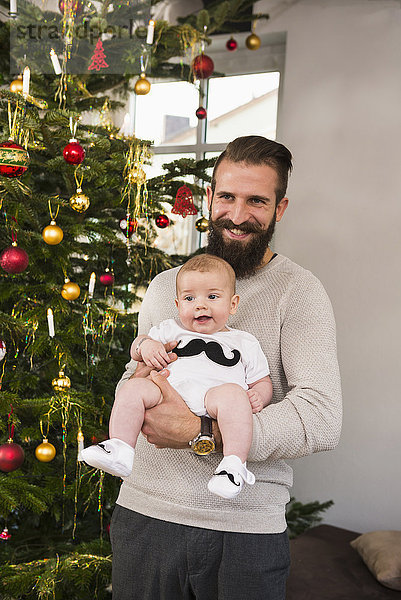 Vater mit Sohn unter dem Weihnachtsbaum