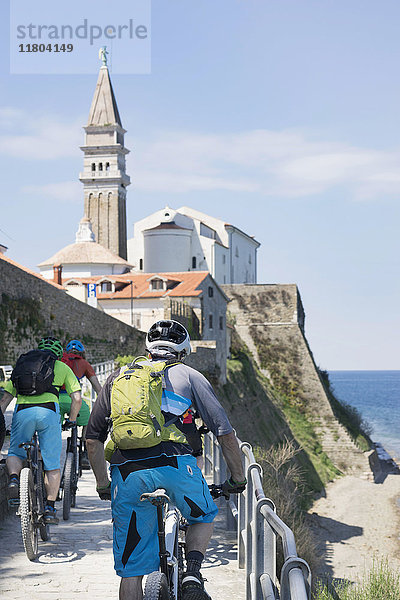 Radfahrer radeln zur Kirche am Meer