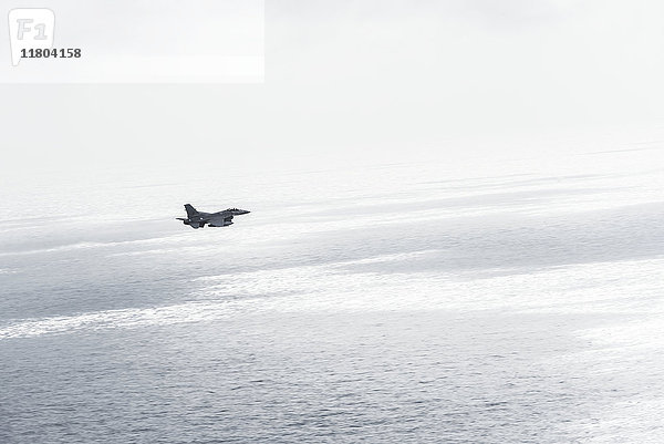 Militärflugzeug über dem Meer