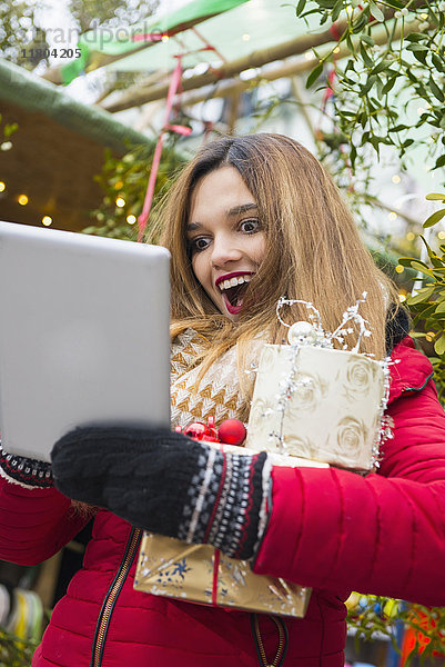 Junge Frau benutzt digitales Tablet auf der Straße