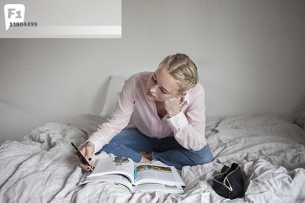 Teenager-Mädchen liest auf dem Bett