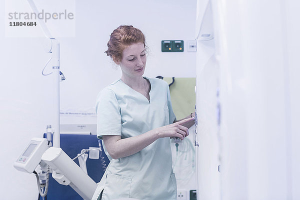 Krankenschwester bedient Röntgengerät