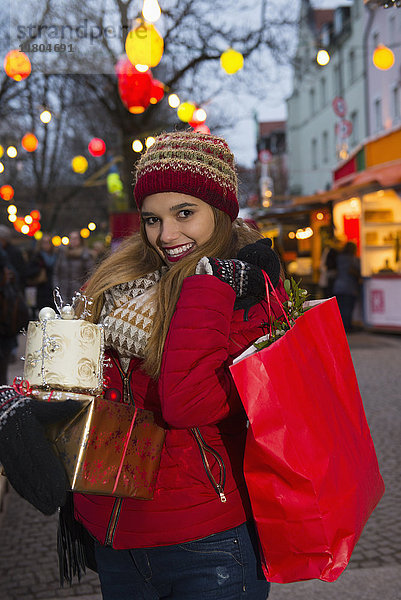 Porträt einer jungen Frau mit Geschenk und Einkaufstasche