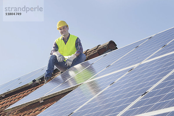 Ingenieur macht Pause bei der Installation von Solarzellen auf dem Hausdach