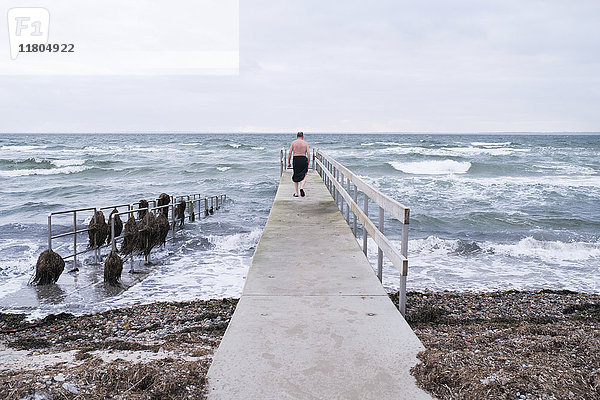 Mann geht auf Pier