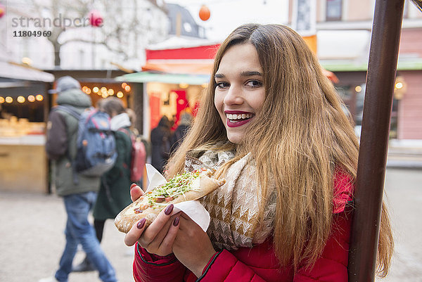 Porträt einer jungen Frau  die Straßenessen isst
