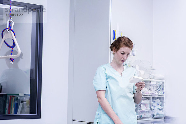 Krankenschwester mit Medikamenten in der Hand im Lagerraum eines Krankenhauses