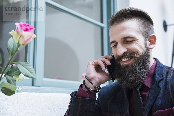 Junger Mann telefoniert in einem Cafe