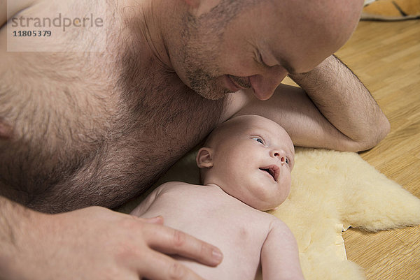 Vater liegt mit seinem Sohn auf dem Holzboden