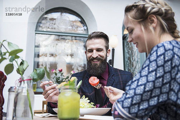 Junges Paar isst Salat im Restaurant