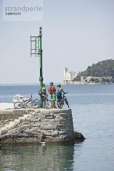 Mountainbiker betrachten die Aussicht  während sie am Meer stehen