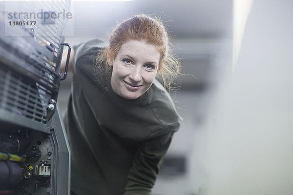 Porträt einer schönen Arbeiterin  die an einer Druckmaschine steht