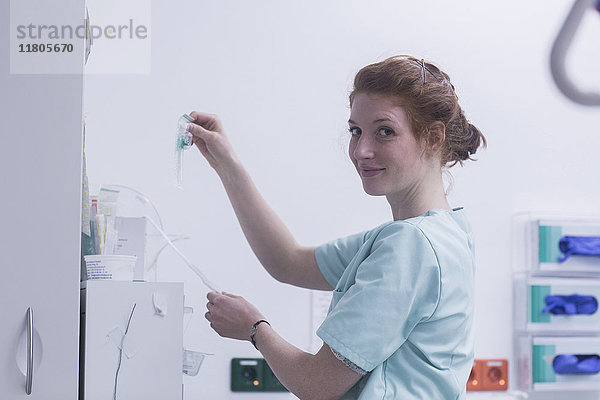 Porträt einer Krankenschwester  die einen IV-Tropf im Krankenhaus hält