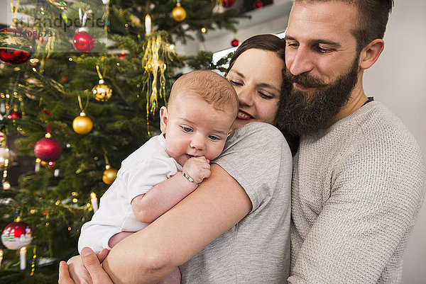 Familie gegen Weihnachtsbaum