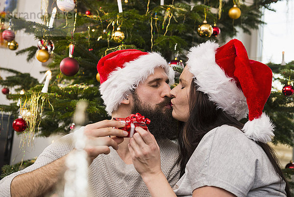 Pärchen tauschen Geschenke aus und küssen sich