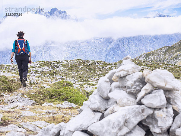 Frau auf einer Wandertour in den Picos de Europa bei Covadonga  Asturien  Nordspanien. Im Hintergrund der Gipfel des Picu Urriellu