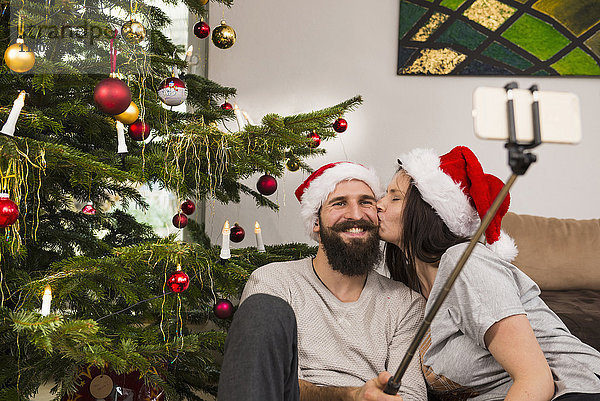 Pärchen nimmt Selfie beim Küssen zu Hause