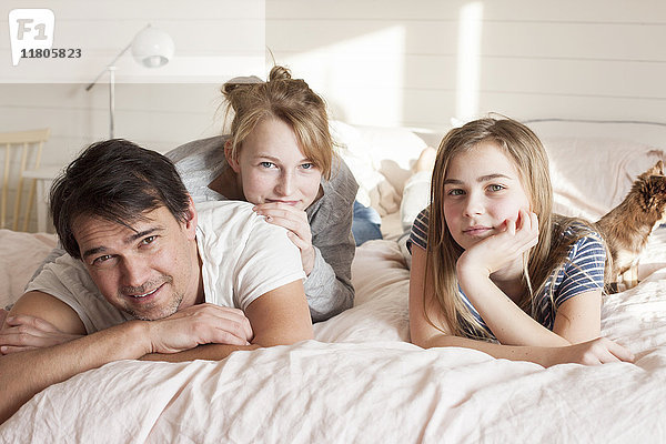 Vater mit Töchtern und im Bett