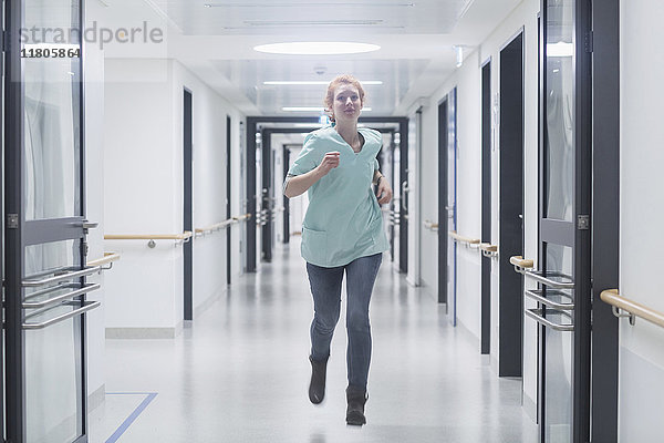 Weibliche Krankenschwester läuft im Krankenhausflur