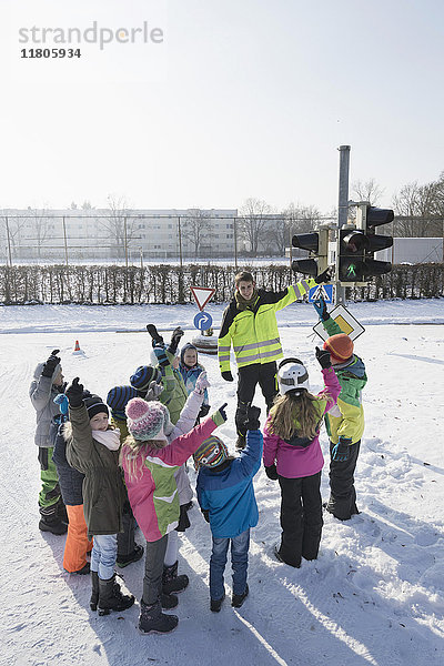 Mann unterrichtet Kinder auf Schneefeld in Verkehrssicherheit