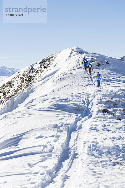 Rückansicht von Skifahrern  die einen Schneeberg besteigen