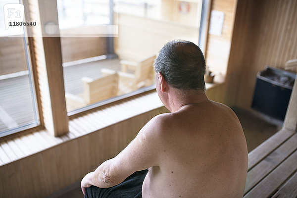 Älterer Mann sitzt in der Sauna