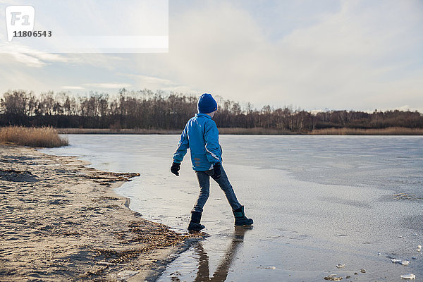 Junge spielt auf gefrorenem See