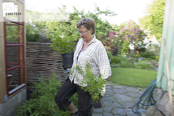 Frau mit Topfpflanzen