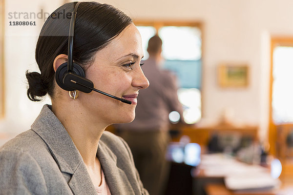 Profil einer lächelnden kaukasischen Geschäftsfrau mit Headset