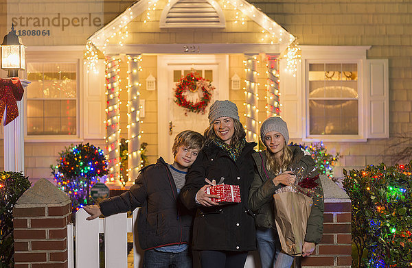 Kaukasische Familie mit Weihnachtsgeschenken auf der Treppe