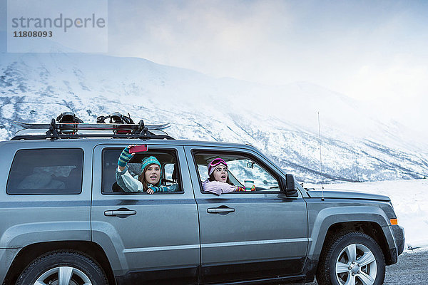 Freunde fotografieren aus dem Auto im Winter