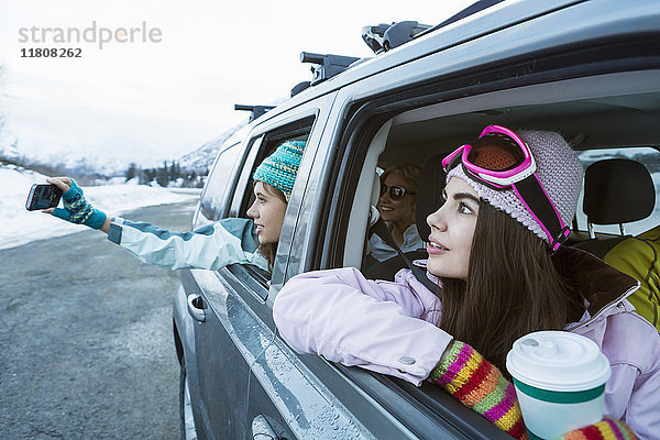 Freunde fotografieren aus dem Auto im Winter