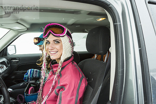 Porträt einer lächelnden kaukasischen Frau im Auto im Winter