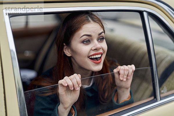 Kaukasische Frau lächelnd auf dem Rücksitz eines Autos