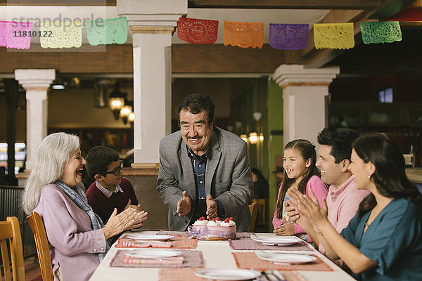 Familie feiert den Geburtstag eines älteren Mannes in einem Restaurant