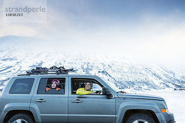 Freunde genießen die Aussicht aus dem Auto im Winter